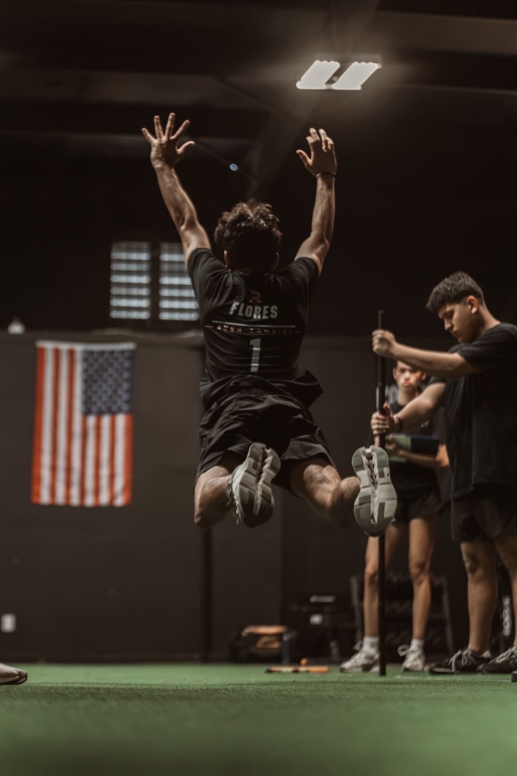 Athlete Flores celebrating with arms raised, American flag in background