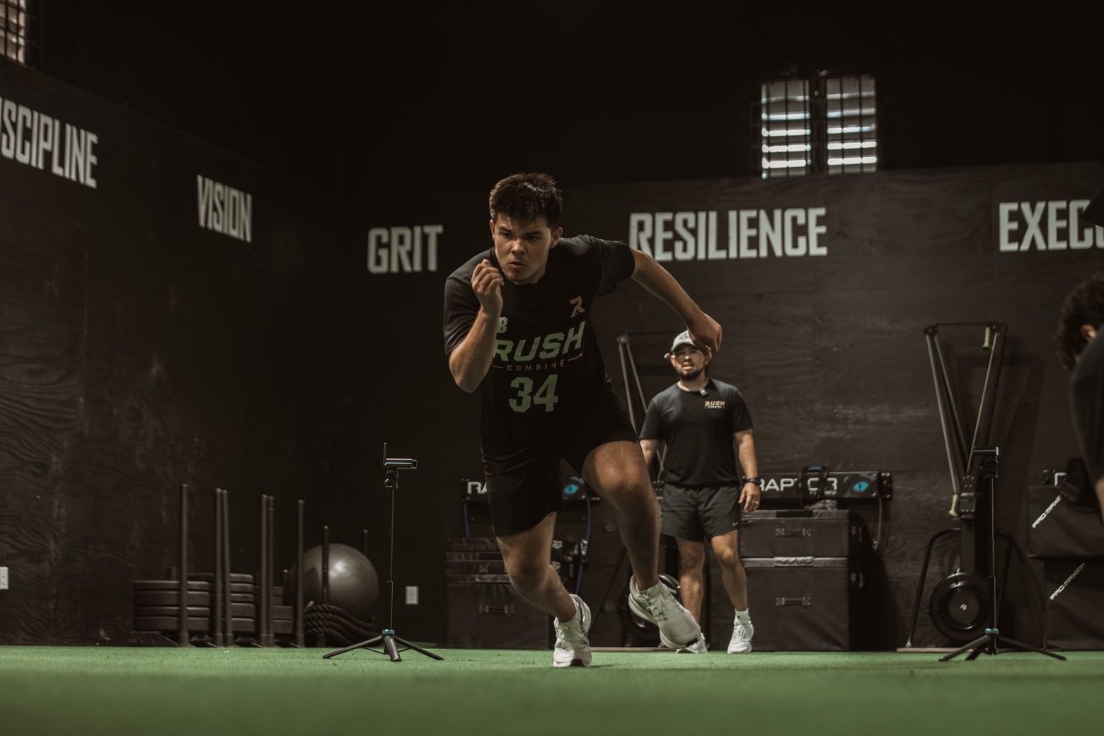 Athlete sprinting off the line in front of the Rush Pillars wall